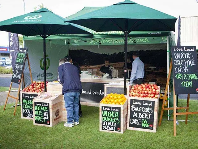 Woolworths Love Local marquee and umbrellas with crates of apples, oranges and lettuce