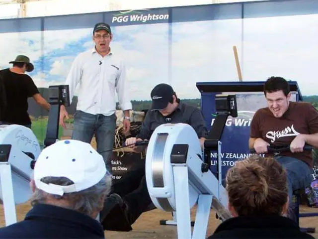 Rowing machine contest held in front of a PGG Wrightson rural landscape backdrop