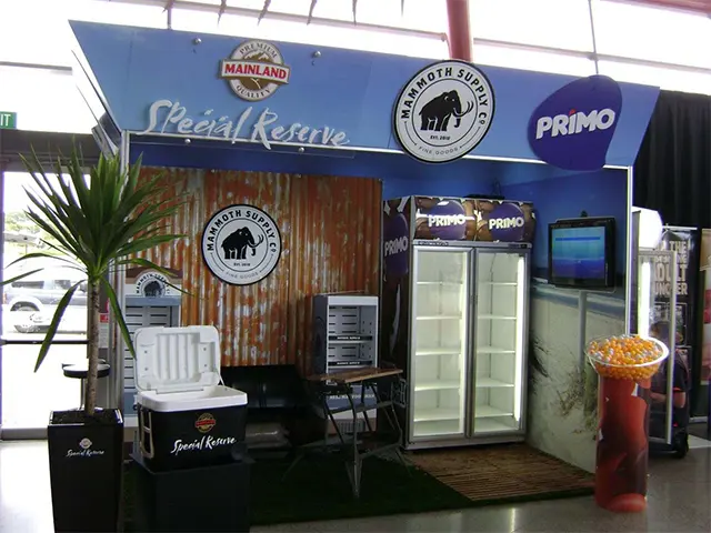 Rustic booth with corrugated iron walls, glass-door fridges and Mainland, Mammoth and Primo logos