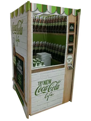 Coca-Cola Life kiosk with a striped awning, white brick-look walls and bottles behind a window