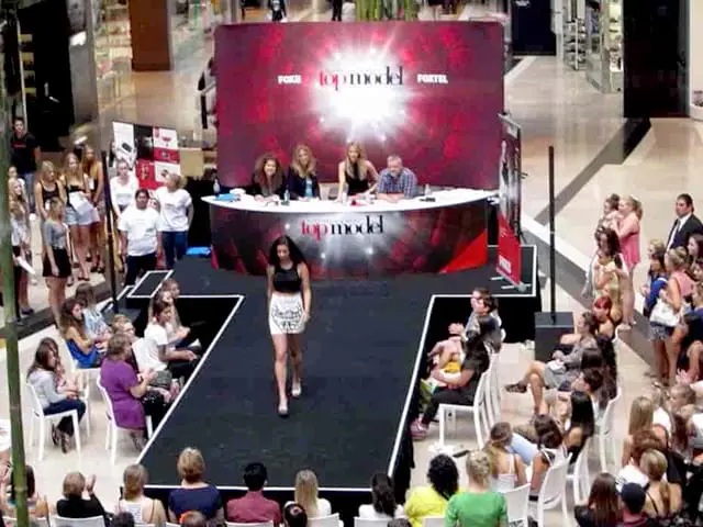 T-shaped black runway and curved judges' desk on an Australia's Next Top Model set