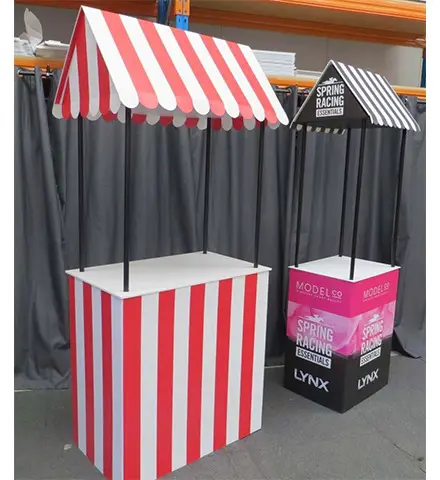Two awning-roofed stall counters, one in red and white stripes and one with Lynx graphics