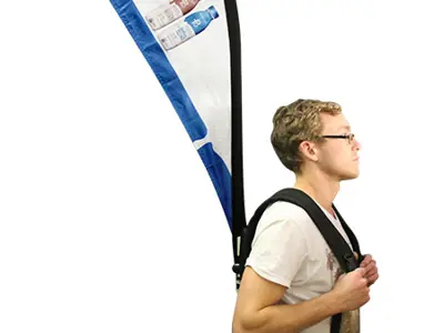 Promoter wearing a curved backpack flag printed with Try the new taste in protein