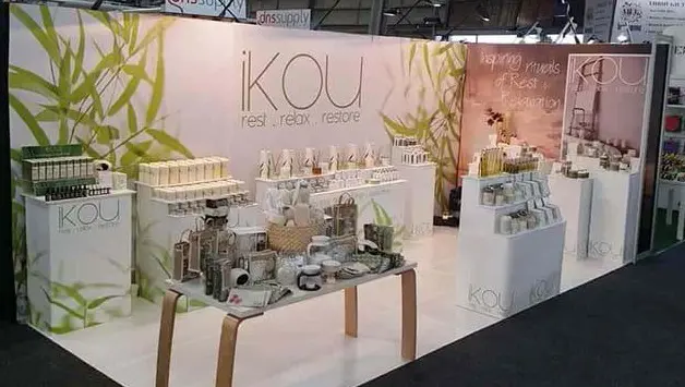 Skincare stand for iKOU with white plinths of different heights and a central timber table