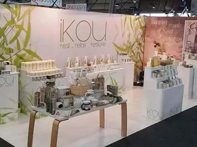 Skincare stand for iKOU with white plinths of different heights and a central timber table