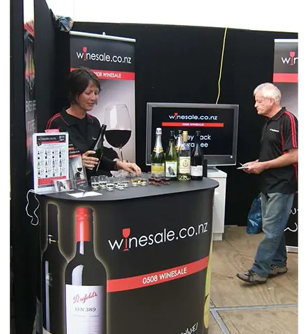 Curved winesale.co.nz counter wrapped in a bottle image with the website and phone number
