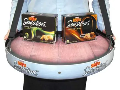 Shapes Sensations tray holding two flavour boxes, worn by a promoter on shoulder straps