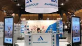 Round overhead banner above a stand with digital totems