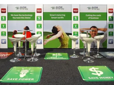 Pulse Energy stand with Save Power floor decals, bar tables and white stools