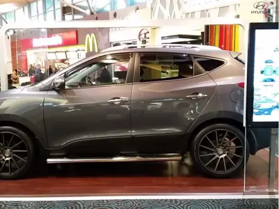 Hyundai SUV on a timber-look platform beside a portrait screen in a food court