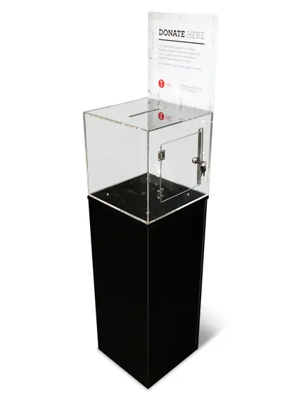 Clear acrylic donation box with a 'Donate Here' sign, raised on a tall black plinth