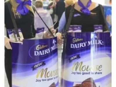Promoters carrying Cadbury Dairy Milk Mousse tubs with packs standing in the open tops