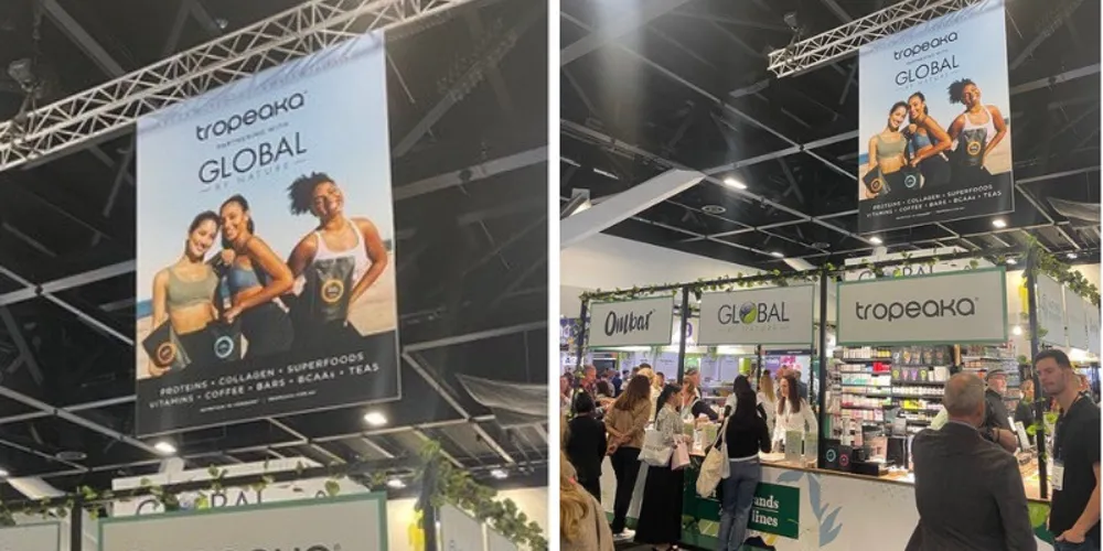 Tropeaka expo stand with tall banner graphics above a busy aisle