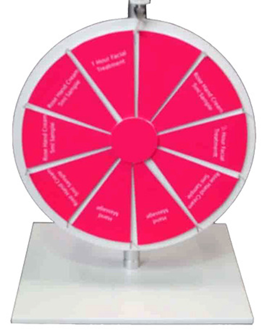 Counter-top prize wheel with pink segments offering a facial, hand massage and hand cream samples
