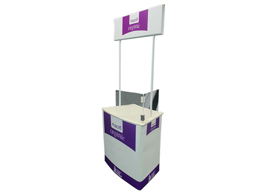 Macro Organic branded demonstration table with a header board on poles and a splash guard fitted behind the work surface