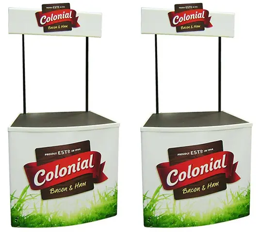 Two Colonial Bacon & Ham counters with grass-printed fronts and raised headers