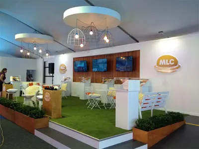 MLC hospitality lounge with raised turf floor, cage pendant lights and white garden furniture