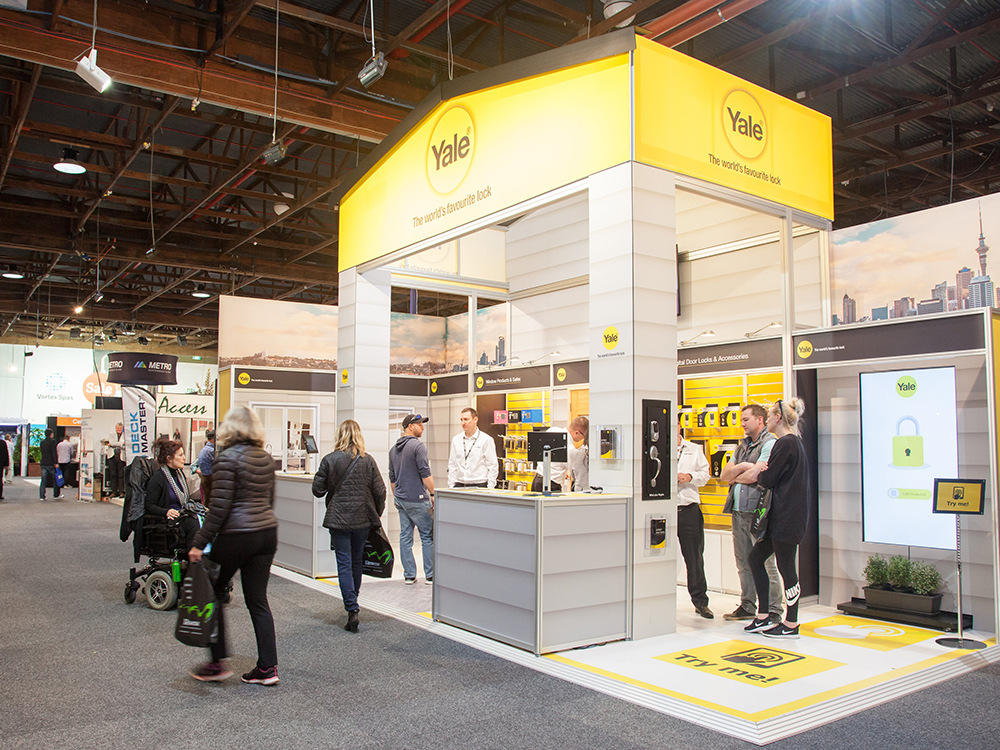 Yale house-shaped stand with a yellow roof, lock walls and a 'Try me' floor graphic