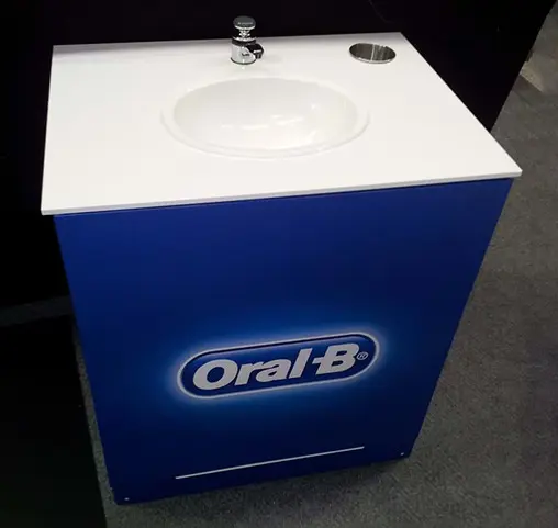 Oral-B sink cabinet with a blue logo front panel, basin, tap and cup holder