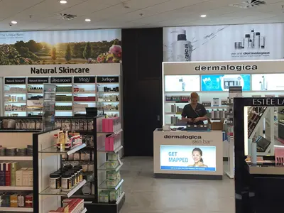 Dermalogica skin bar with an illuminated header and lit back shelves beside a skincare wall