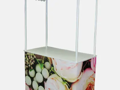 Rose-print demo table with a scalloped pitched roof on slim white posts